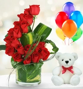 red-roses-and-a-white-rose-in-a-vase-accompanied-by-a-teddy-bear-and-balloons